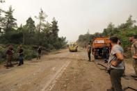 Local residents gather at a forest during a wildfire in Kechries village on the island of Evia, about 144 kilometers (90 miles) north of Athens, Greece, Thursday, Aug. 5, 2021. Forest fires fueled by a protracted heat wave raged overnight and into Thursday in Greece, threatening the archaeological site at the birthplace of the modern Olympics and forcing the evacuation of dozens of villages. (AP Photo/Thodoris Nikolaou)