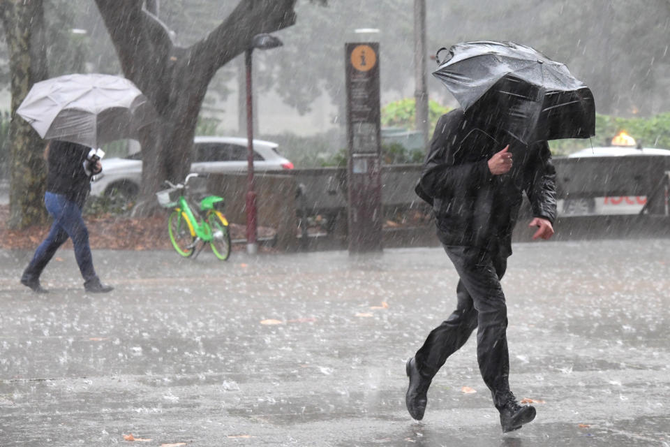 Pedestrians hold umbrellas as they walk in heavy rain in Sydney's CBD. Source: AAP