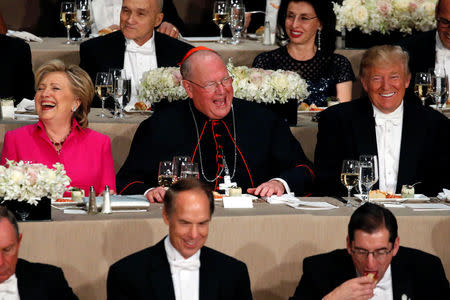 Democratic presidential nominee Hillary Clinton (L-R), Archbishop of New York Cardinal Timothy Dolan and Republican presidential nominee Donald Trump sit together at the Alfred E. Smith Memorial Foundation dinner in New York. REUTERS/Jonathan Ernst