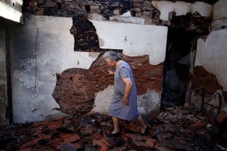 Albertina Miranda walks inside her burnt house after a forest fire in Lagares, near Santa Comba Dao, Portugal October 17, 2017. REUTERS/Pedro Nunes