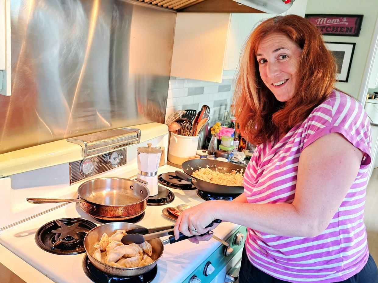 Jennifer cooking dumplings and rice on the stove.