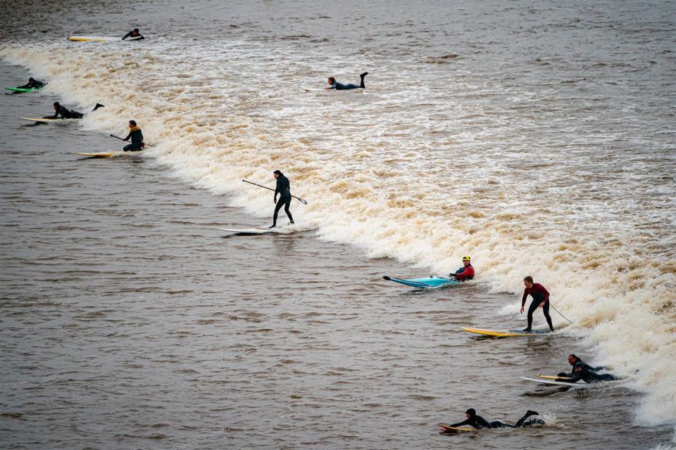 Surfers enjoy the unique event on Tuesday morning (PA)