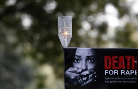 A candle is seen on a placard during a protest in New Delhi December 29, 2012. REUTERS/Adnan Abidi/Files