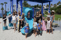 Hillary Salway, fifth from left, poses for a photo with her children, her friends and their children Monday, July 13, 2020, in San Clemente, Calif. Salway plans to send her children back to school in the fall. On one side are the parents saying, let kids be kids. They object to masks and social distancing at schools, arguing both could be detrimental to their children's well being, and want schools to reopen full-time. On the other side are parents and many teachers calling for things that would have been unimaginable pre-pandemic: part-time school, face coverings for all or full online curriculum. (AP Photo/Ashley Landis)