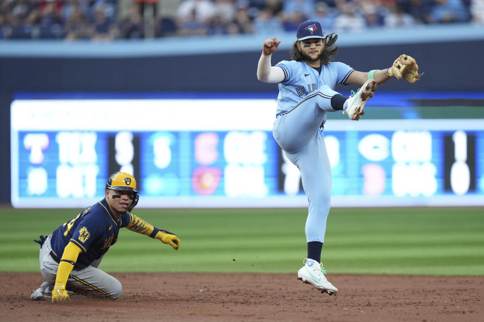 Toronto Blue Jays shortstop Bo Bichette watches his throw to first after forcing out Milwaukee Brewers' William Contreras (24) at second base during the third inning of a baseball game Tuesday, May 30, 2023, in Toronto. Christian Yelich was out at first. (Nathan Denette/The Canadian Press via AP)