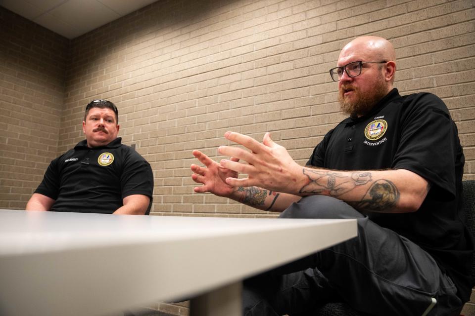 T.J. Wood (right), of the West Des Moines Police crisis intervention team, talks with officer Kenneth Bensley (left) Wednesday, Feb. 21, 2024, at the West Des Moines Police Departments.
