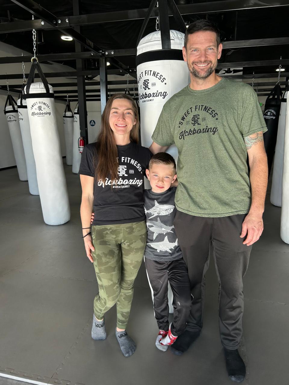 Jenna Rodriguez and husband Michael Long stand with their son, Colson Long, inside Sweet Fitness Kickboxing in Redding. The husband-and-wife team opened the gym in the Target shopping center on Jan. 1, 2024.