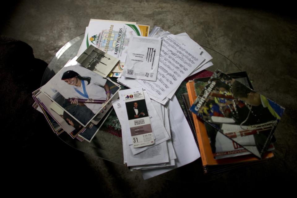 A picture of Karen Palacios, left, stands on a coffee table at her house in Los Teques in the outskirts of Caracas, Venezuela, Tuesday, July 16, 2019. Karen Palacios who plays the clarinet and was cut from the National Philharmonic for criticizing the government, and who was detained for 6 weeks, was released today. (AP Photo/Ariana Cubillos)