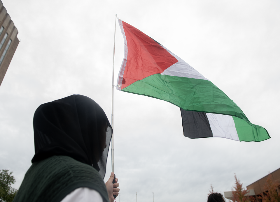 Isra Shaikh, 17, of Cleveland holds a Palestinian flag.