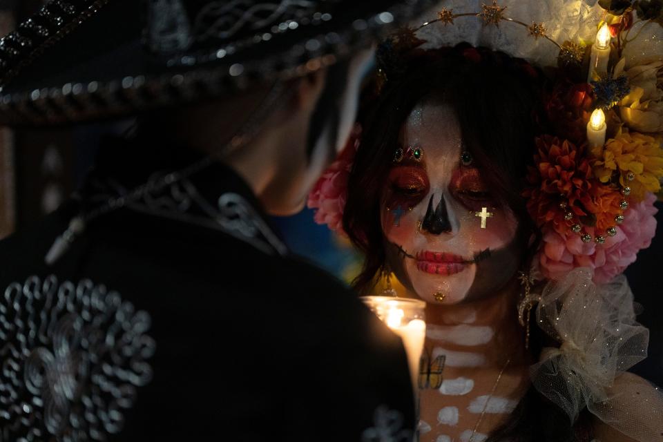 Vivianna Leon holds a candle Nov. 2, 2023, during a Día de Los Muertos celebration at Riverview Park in Jersey City.