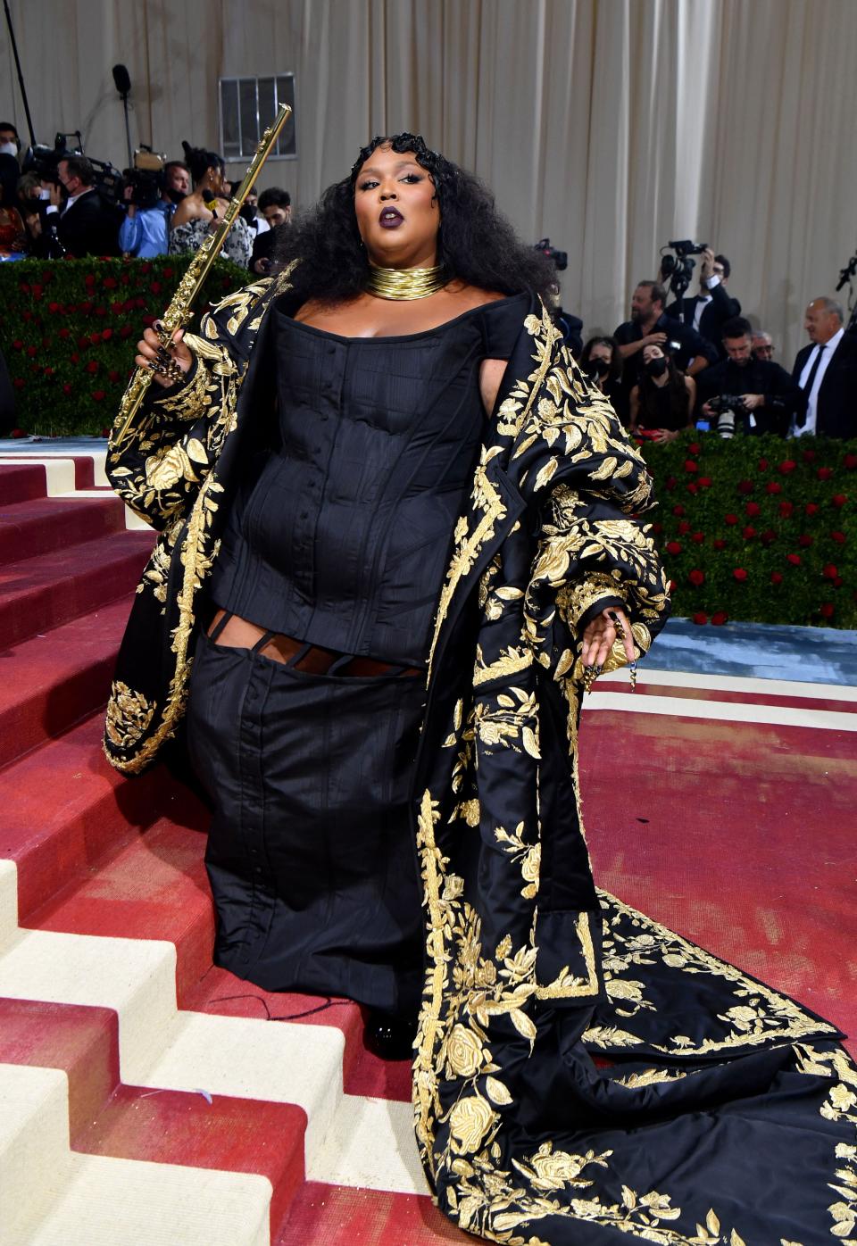 Lizzo in a black gown and black-and-gold cape at the 2022 Met Gala