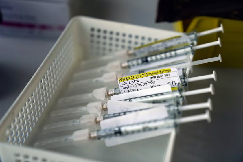 FILE - In this Jan. 7, 2021, file photo syringes containing the Pfizer-BioNTech COVID-19 vaccine sit in a tray in a vaccination room at St. Joseph Hospital in Orange, Calif. Taking a new direction to speed release of coronavirus vaccines, President-elect Joe Biden's office said Friday he would end the current practice of holding back vaccine doses to guarantee that people who get their first shot can also get a required second inoculation three weeks later. (AP Photo/Jae C. Hong, File)