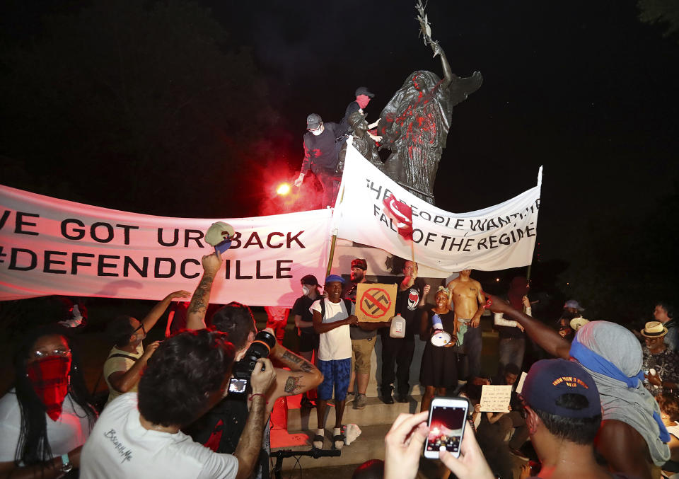 <p>Protesters climb and spray-paint a Confederate monument Sunday, Aug. 13, 2017, at Piedmont Park in Atlanta, Ga. The peace monument at the 14th Street entrance depicts an angel of peace stilling the hand of a Confederate soldier about to fire his rifle. Protesters decrying hatred and racism converged around the country on Sunday, saying they felt compelled to counteract the white supremacist rally that spiraled into deadly violence in Virginia. (Curtis Compton/Atlanta Journal-Constitution via AP) </p>