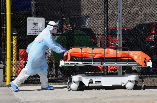 A staff member at the Wyckoff Heights Medical Center in New York moves a body to a refrigerated truck on April 2, 2020, as coronavirus cases ravaged the city and state. (Photo: ANGELA WEISS/AFP via Getty Images)