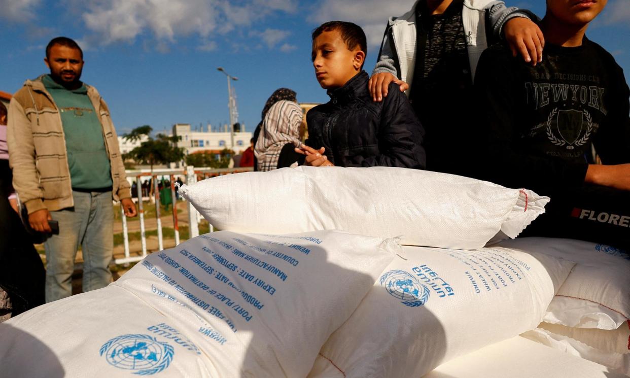 <span>Palestinians gather to receive flour bags distributed by UNRWA in Rafah in southern Gaza. Australia has frozen an additional $6m in aid to UNRWA after allegations that a number of staff were involved in the 7 October attacks on Israel.</span><span>Photograph: Ibraheem Abu Mustafa/Reuters</span>