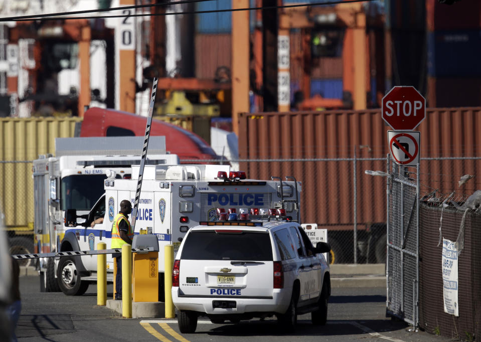 Officials arrive at Port Newark to investigate reports of stowaways in a container inside a ship, Wednesday, June 27, 2012, in Newark, N.J. The Coast Guard suspects there are stowaways in a container that was loaded on a ship. Coast Guard spokesman Charles Rowe says a boarding party heard sounds consistent with people coming from the container. The container was loaded aboard The Villa D'Aquarius in India. The manifest says the container was carrying machine parts to be unloaded in Norfolk, Va. (AP Photo/Julio Cortez)