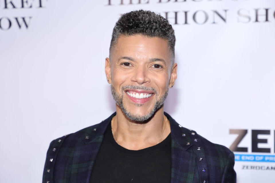 A closeup of Wilson Cruz smiling