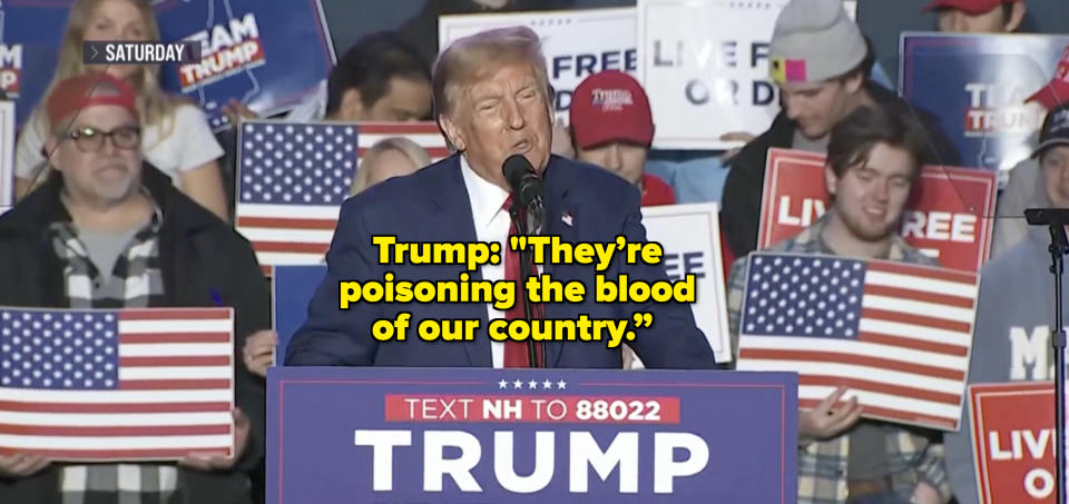 Donald Trump speaks at a rally, surrounded by supporters holding American flags and "Live Free or Die" signs