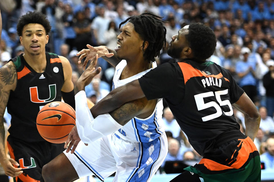 Feb 13, 2023; Chapel Hill, North Carolina, USA; Miami (Fl) Hurricanes guard Wooga Poplar (55) knocks the4 ball away from North Carolina Tar Heels guard Caleb Love (2) in the second half at Dean E. Smith Center. Mandatory Credit: Bob Donnan-USA TODAY Sports