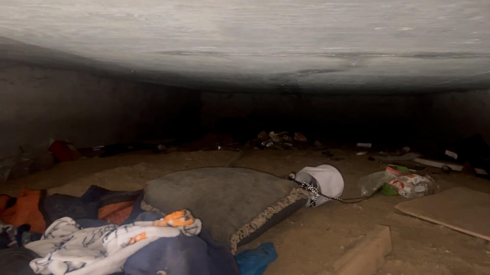A homeless encampment under a state office building’s patio in Lansing. (WLNS)