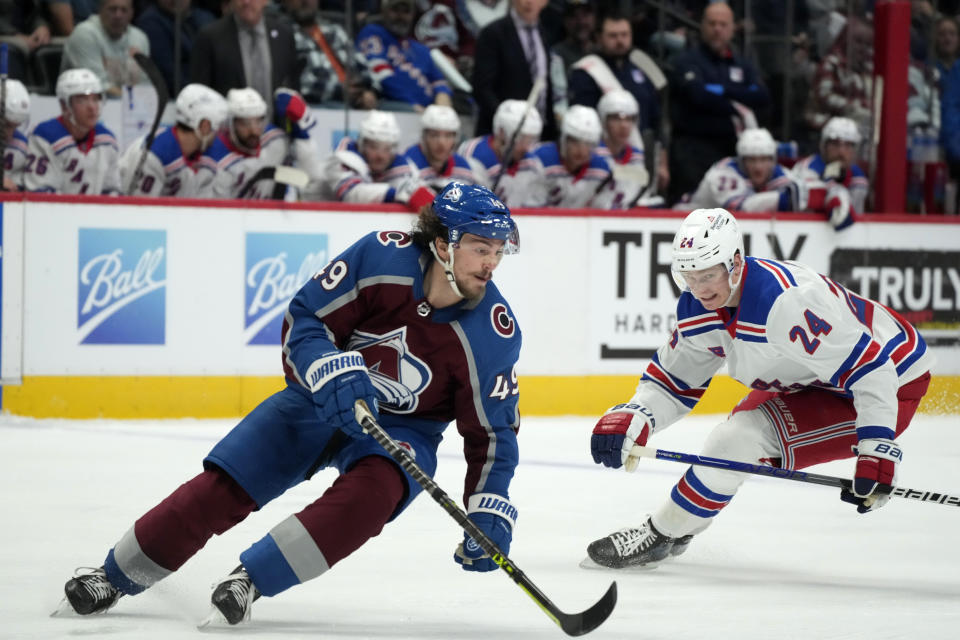 Colorado Avalanche defenseman Samuel Girard, left, pursues the puck with New York Rangers right wing Kaapo Kakko, right, in the second period of an NHL hockey game Friday, Dec. 9, 2022, in Denver. (AP Photo/David Zalubowski)