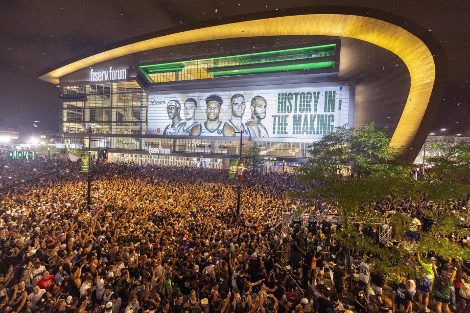 FILE - Fans cheer outside Fiserv Forum after the Milwaukee Bucks defeated the Phoenix Suns in Game 6 of the NBA basketball finals to win the NBA championship Tuesday, July 20, 2021, in Milwaukee. (AP Photo/Jeffrey Phelps)