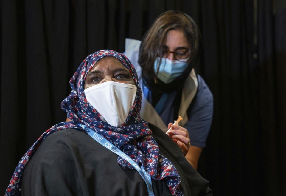 A woman, name not given, is vaccinated at a Covid-19 pop-up vaccination centre, at the East London Mosque in Whitechapel, London, Saturday Feb. 6, 2021. Britain's vaccination program is pushing to offer a vaccination to aged, vulnerable and care workers by mid-February. (Dominic Lipinski/PA via AP)