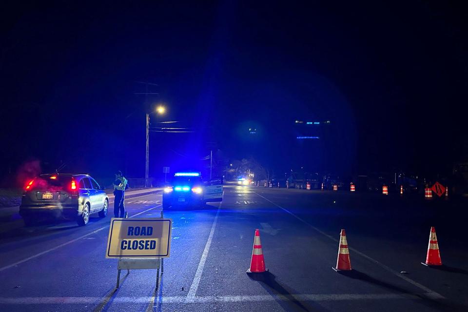 Police block a roadway in Waltham, Mass., after a person in a vehicle struck and injured utility workers before stealing a police cruiser, Wednesday, Dec. 6, 2023. The driver in the suburb of Boston crashed the cruiser before being captured, law enforcement officials said. (AP Photo/Michael Casey) ORG XMIT: MAMC101