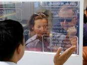 French tourists Isabelle and Marc Rigaud use an automated translation window at the Seibu-Shinjuku station in Tokyo