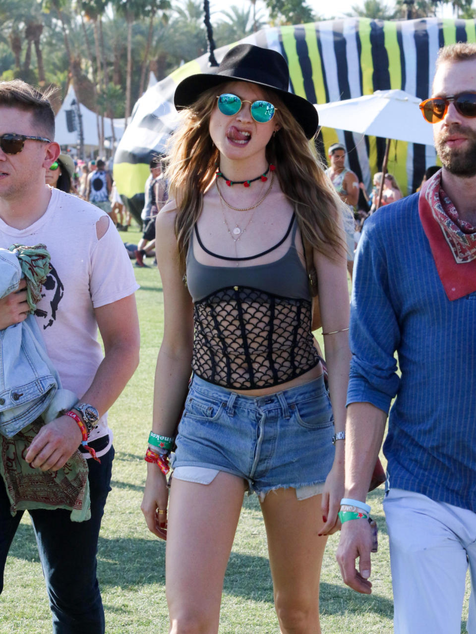 The wide-brimmed hat, round sunnies, jean shorts, and layered neclaces are all Coachella staples, but Behati Prinsloo also brought some Victoria’s Secret to the festival with her with a sheer cage tank.