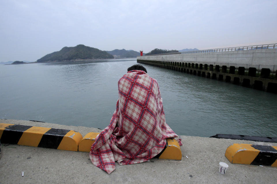 A relative waits for their missing loved one at a port in Jindo, South Korea, Wednesday, April 16, 2014. A ferry carrying 459 people, mostly high school students on an overnight trip to a tourist island, sank off South Korea's southern coast on Wednesday, leaving nearly 300 people missing despite a frantic, hours-long rescue by dozens of ships and helicopters. (AP Photo/Ahn Young-joon)