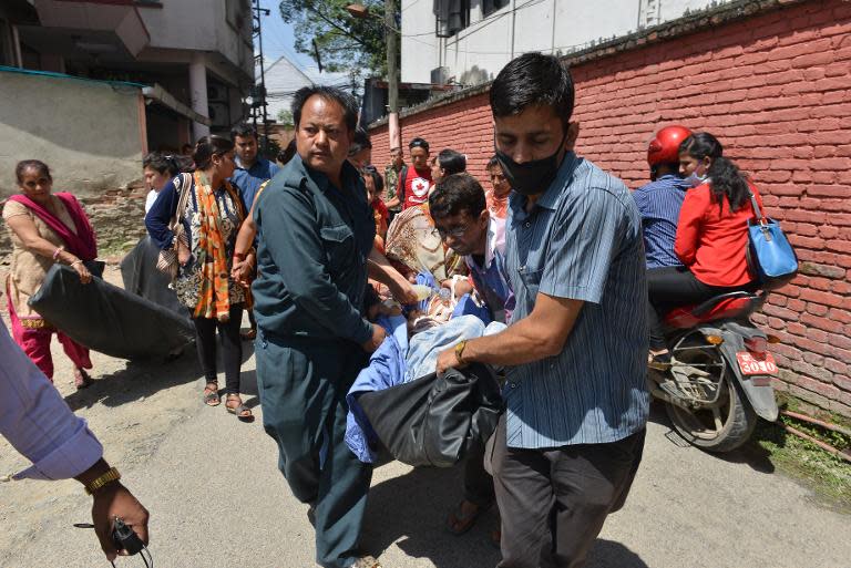 Nepalese patients are carried out of a hospital building in Kathmandu as a new earthquake rattles the Himalayan nation on May 12, 2015