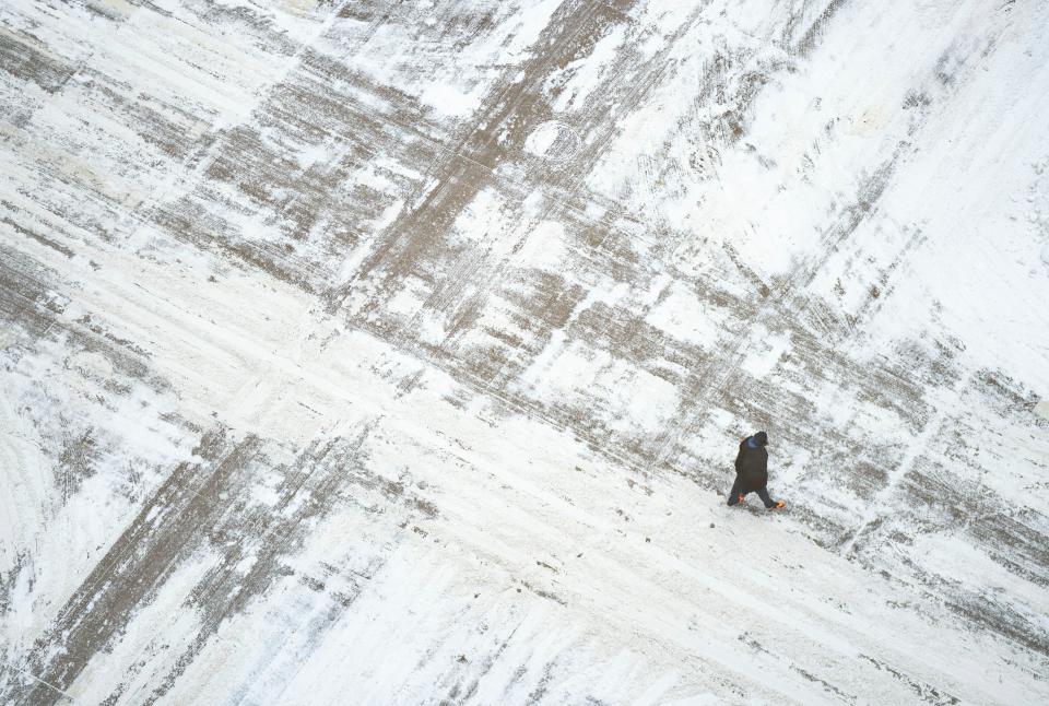 A man crosses a snow covered South Sixth St on Wednesday, February 22 in downtown Minneapolis. (Alex Kormann/Star Tribune via AP) (AP)