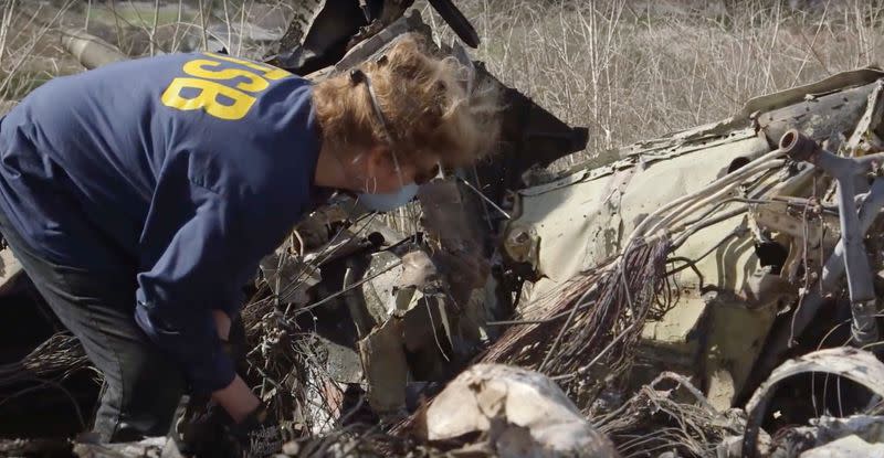 An investigator works at the site of the helicopter crash that killed Kobe Bryant and eight others in a screen grab taken in Calabasas