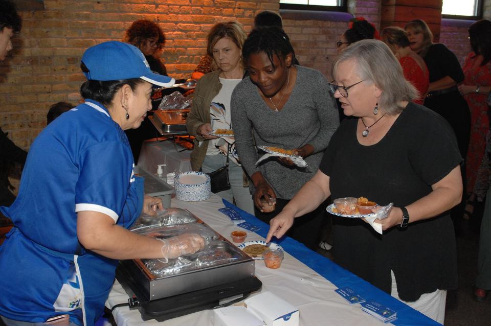 Maria Monge, owner of Pupuseria Los Angeles, serves pupusas to guests attending the Lubar Center's Latino Heritage Dinner on Sept. 18, 2023.