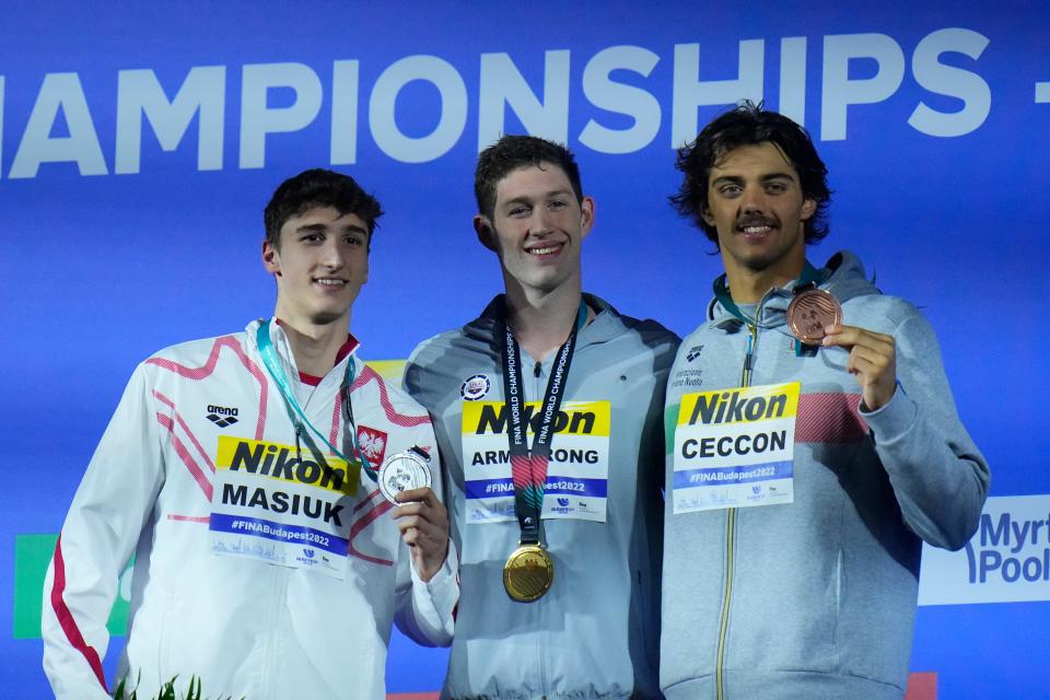 Hunter Armstrong, center, poses for a photo after the men's 50-meter backstroke at the 19th FINA World Championships in Budapest, Hungary, Saturday, June 25, 2022. He is joined by Ksawery Masiul, left, from Poland, and Thomas Ceccon, right, from Italy.