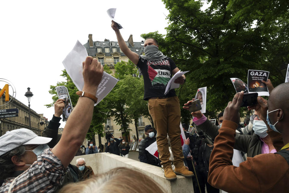 A protester distributes leaflets during a protest in solidarity with Palestinians, in Paris, Wednesday, May 12, 2021. (AP Photo/Thibault Camus)