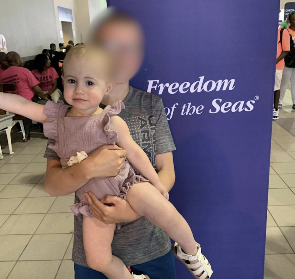 A little girl, who died after she fell from a cruise ship docked in San Juan while allegedly being held by her grandfather, pictured with a boy next to a Freedom of the Seas sign.