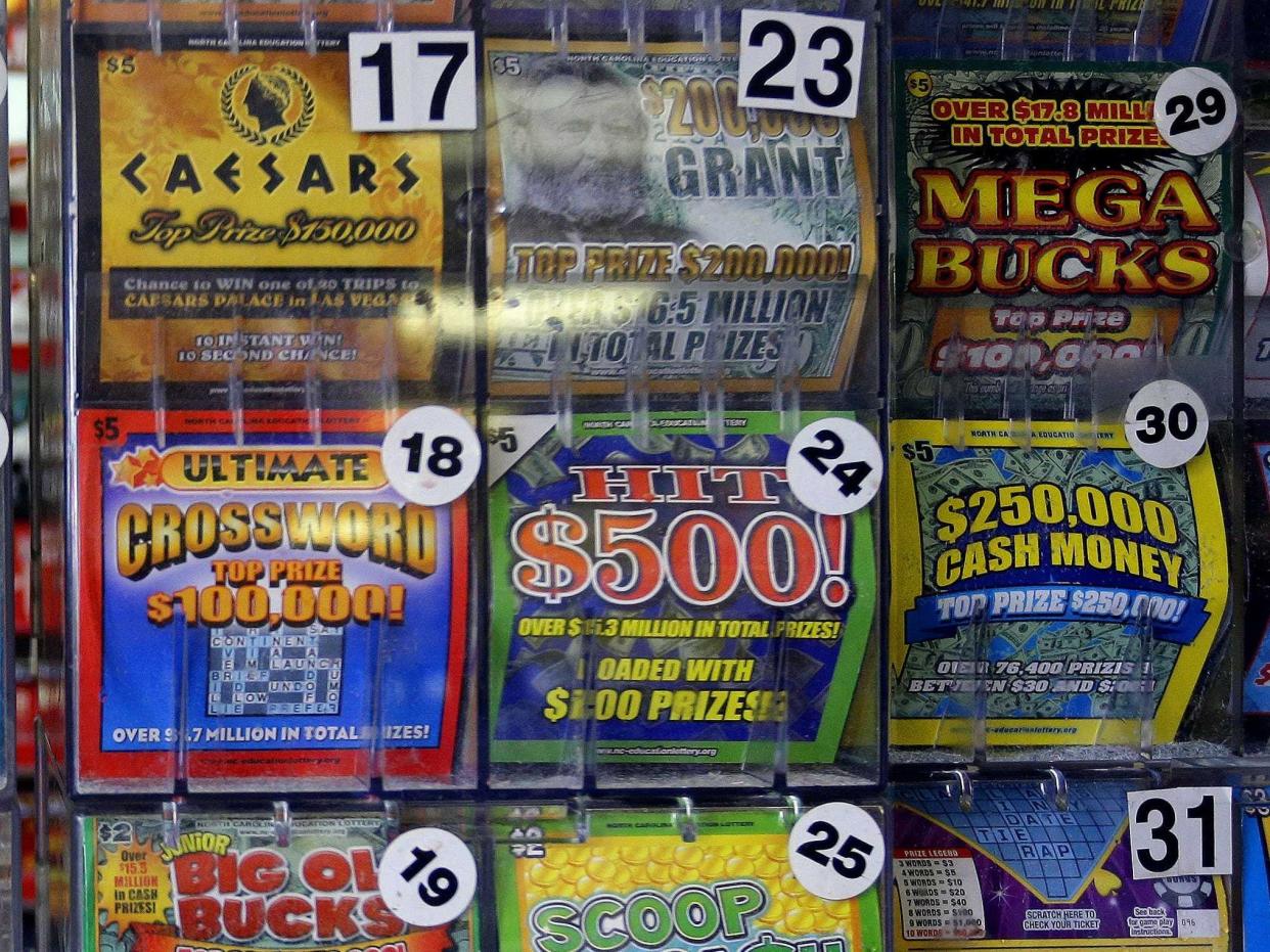 A plastic shelf filed with various lottery scratch tickets