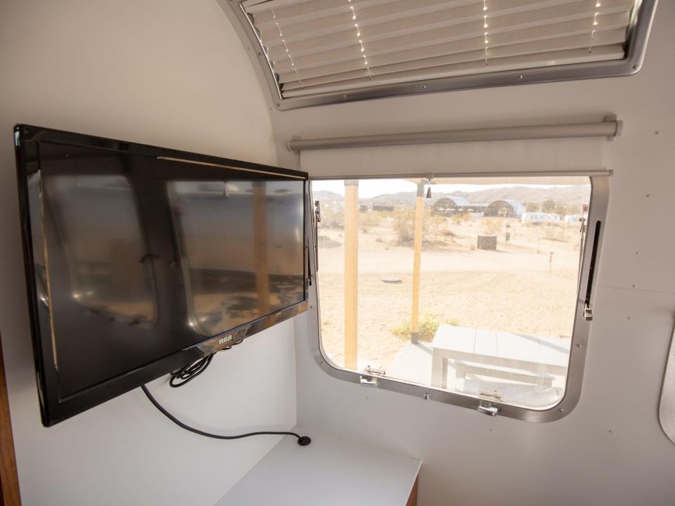 Autocamp Joshua Tree's Airsteram trailer with a TV next to a window.