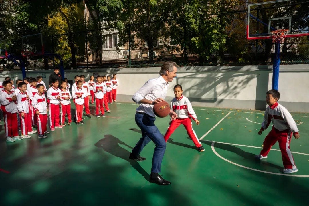 California Gov. Gavin Newsom playing basketball with students from the Beijing Yuying School.