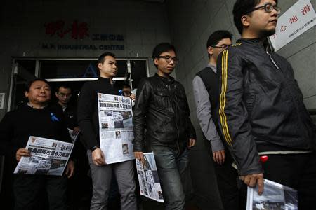 Journalists and editors from Ming Pao holding front pages of their newspaper walk out of their office for a protest against violence in Hong Kong February 27, 2014, after Wednesday's attack on their former chief editor Kevin Lau. REUTERS/Bobby Yip