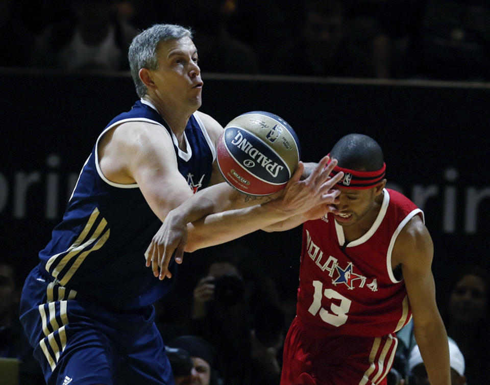 East's United States Secretary of Education Arne Duncan, left, battles West's Terrence Jenkins (13) for a loose ball in the first half as they participate in the NBA All-Star Celebrity basketball game in New Orleans, Friday, Feb. 14, 2014. East won 60-56. (AP Photo/Bill Haber)