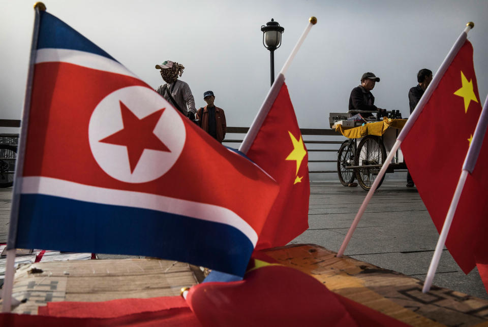 <p>Chinese vendors sell North Korea and China flags on the boardwalk next to the Yalu river in the border city of Dandong, Liaoning province, northern China across from the city of Sinuiju, North Korea on May 24, 2017 in Dandong, China. (Photo: Kevin Frayer/Getty Images) </p>