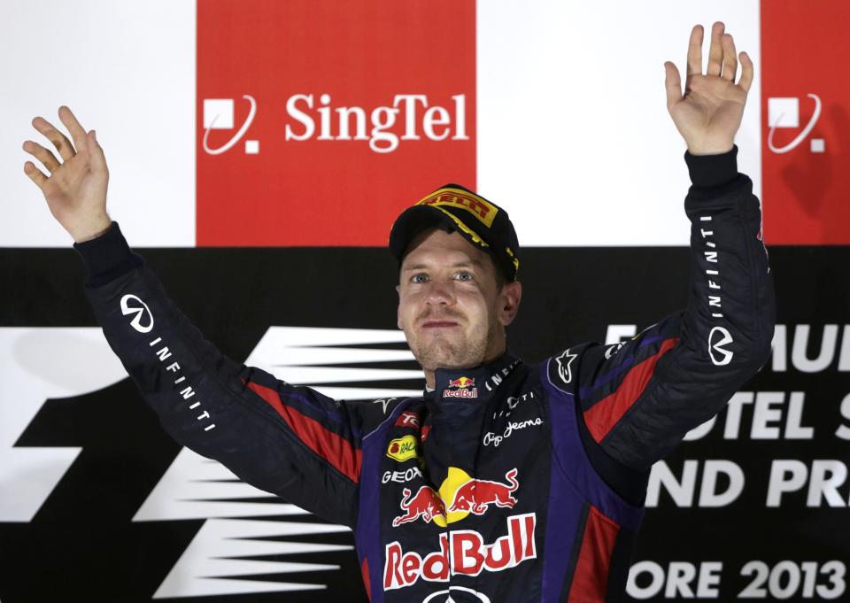 Red Bull Formula One driver Sebastian Vettel of Germany waves on the podium after winning the Singapore F1 Grand Prix at the Marina Bay street circuit in Singapore September 22, 2013. REUTERS/Pablo Sanchez (SINGAPORE - Tags: SPORT MOTORSPORT F1)