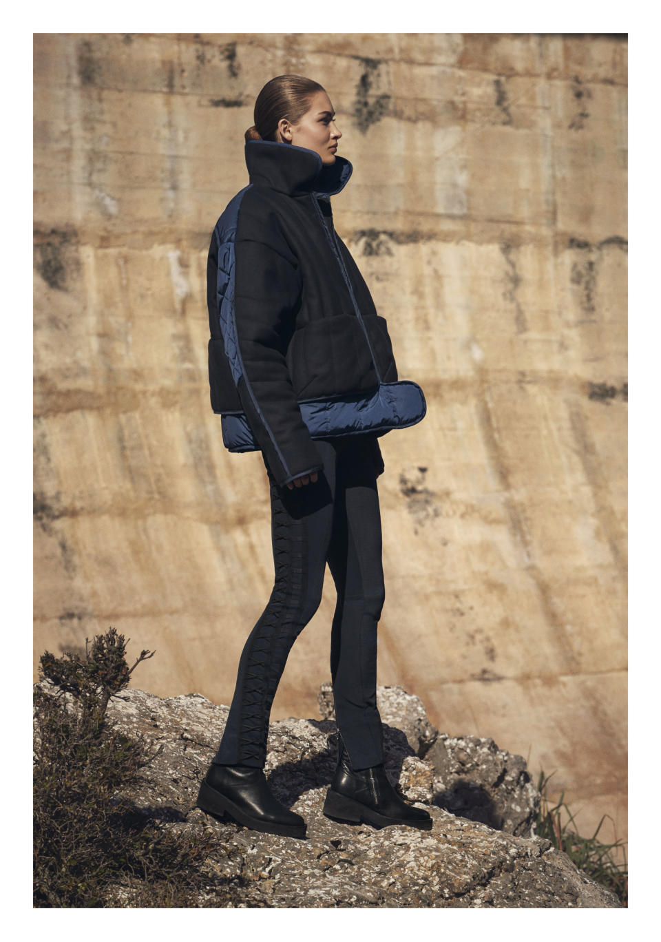 Model Grace Elizabeth in a black-and-navy puffer jacket, cross-stitched pants, and boots from H&M Studio AW17, photographed by Christian MacDonald, styled by Ludivine Poiblanc, in Mallorca, Spain. (Photo: Courtesy of H&M)