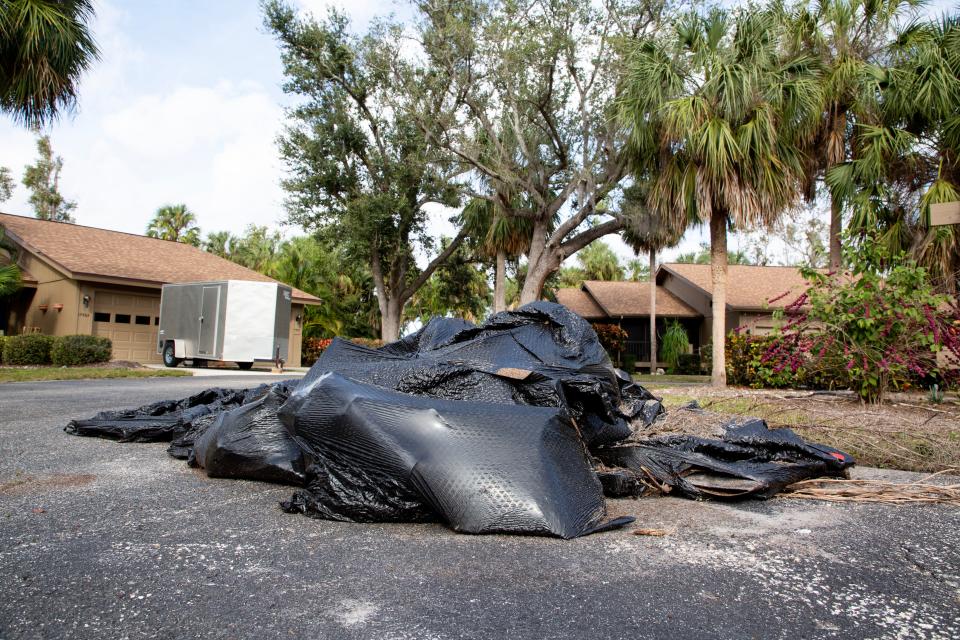 A pile of bags filled with roofing shingles sits in a cul-de-sac in Island Park Village on Friday, Jan. 5, 2024. Construction debris still litters parts of the community, and many homes are still being repaired after damage from Hurricane Ian.