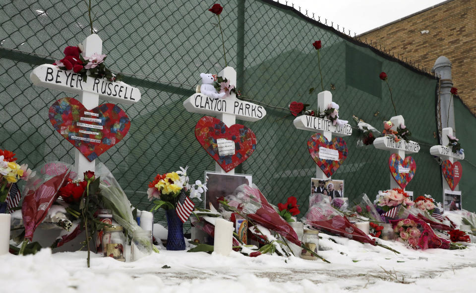 Crosses are placed for the victims of a mass shooting Sunday, Feb. 17, 2019, in Aurora, Ill., near Henry Pratt Co. manufacturing company where several were killed on Friday. Authorities say an initial background check five years ago failed to flag an out-of-state felony conviction that would have prevented a man from buying the gun he used in the mass shooting. (AP Photo/Nam Y. Huh)