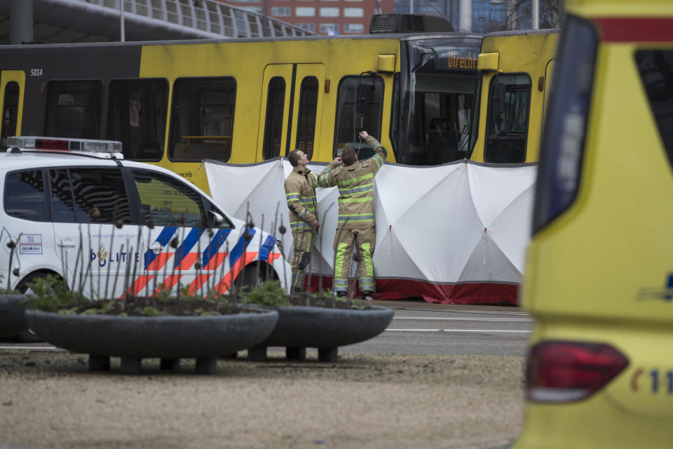 Rescue workers install a screen on the spot where a human shape was seen under a white blanket following a shooting in Utrecht, Netherlands. Source: AP