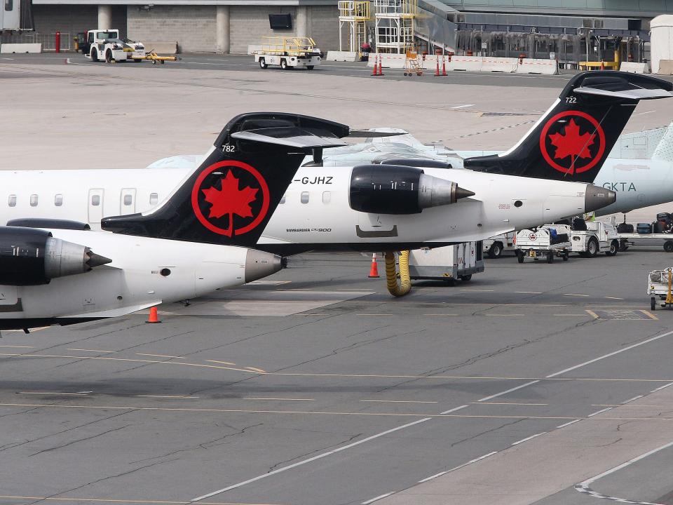 Air Canada planes sit on the tarmac at the airport.